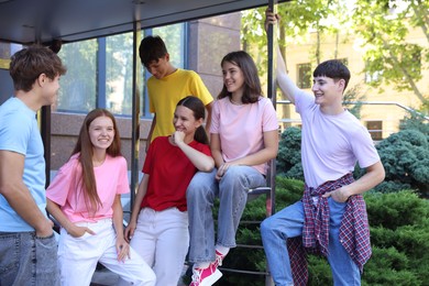 Photo of Group of happy teenage friends spending time together outdoors