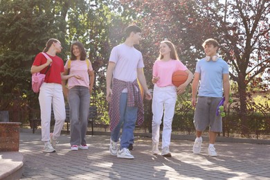 Photo of Group of happy teenage friends spending time together outdoors