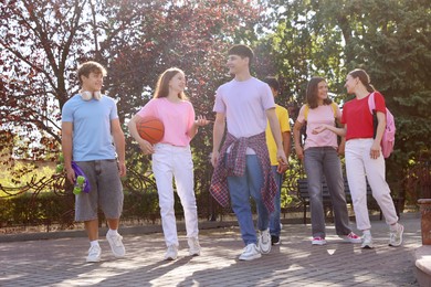 Photo of Group of happy teenage friends spending time together outdoors