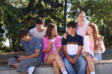 Photo of Group of happy teenage friends spending time together outdoors