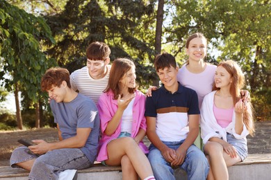 Photo of Group of happy teenage friends spending time together outdoors