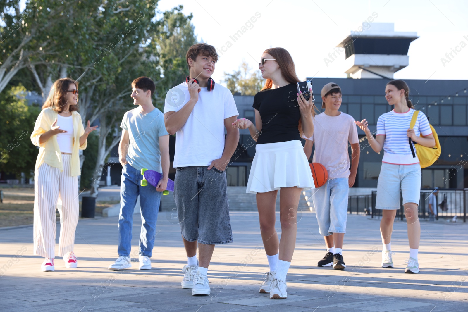 Photo of Group of happy teenage friends spending time together outdoors