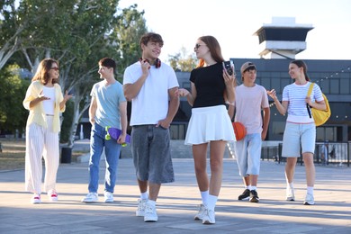 Photo of Group of happy teenage friends spending time together outdoors