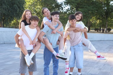 Photo of Group of happy teenage friends spending time together outdoors
