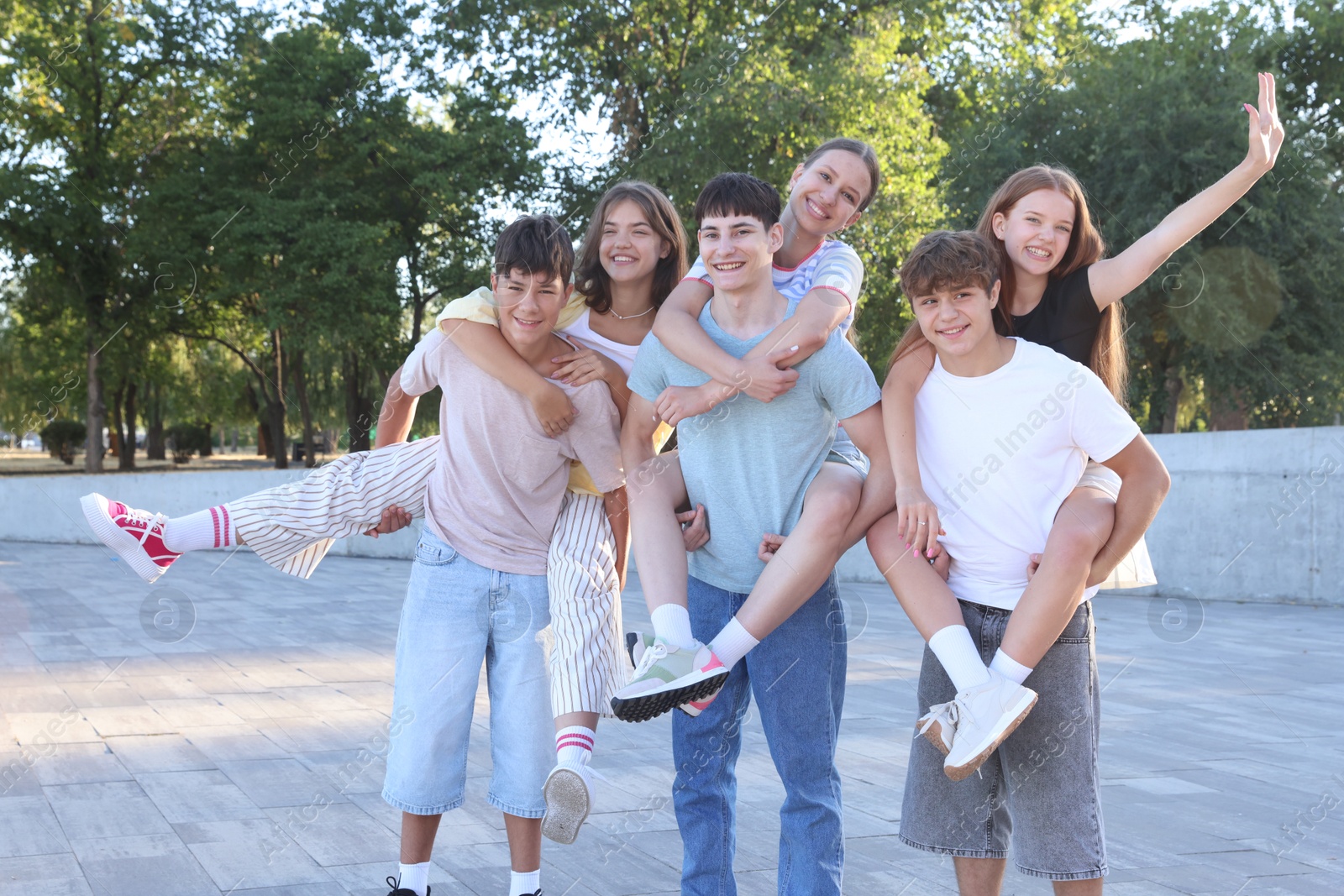 Photo of Group of happy teenage friends spending time together outdoors