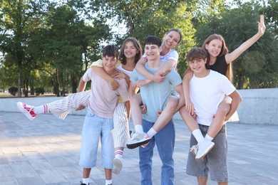 Photo of Group of happy teenage friends spending time together outdoors