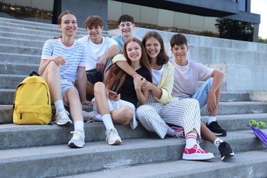 Photo of Portrait of happy teenage friends together on steps outdoors