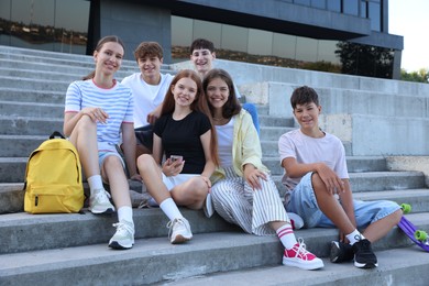 Photo of Portrait of happy teenage friends together on steps outdoors