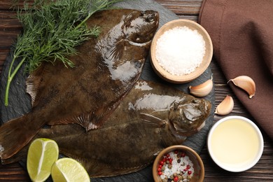 Photo of Fresh flounder fish, spices and products on wooden table, flat lay. Raw seafood