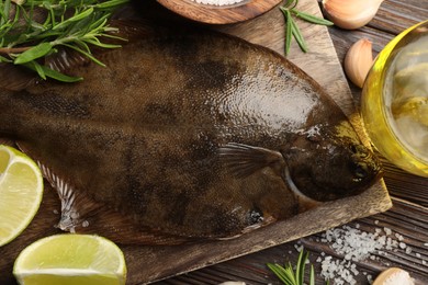 Photo of Fresh flounder fish, salt and products on wooden table, flat lay. Raw seafood