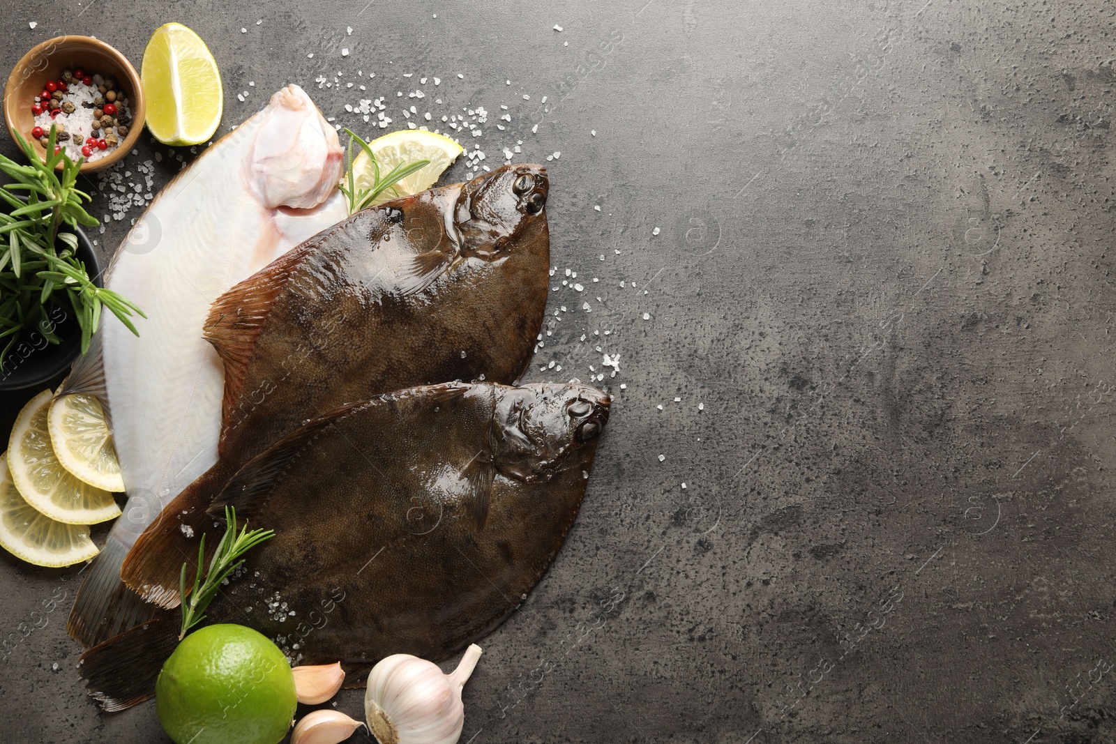 Fresh flounder fish, spices and products on grey textured table, flat lay with space for text. Raw seafood Photo of Fresh flounder fish, spices and products on grey textured table, flat lay with space for text. Raw seafood