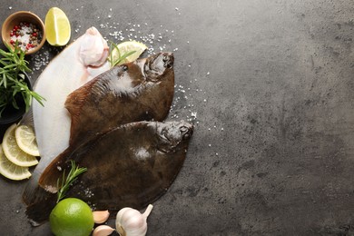Photo of Fresh flounder fish, spices and products on grey textured table, flat lay with space for text. Raw seafood