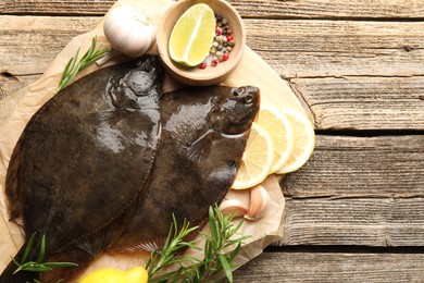 Photo of Fresh flounder fish, spices and products on wooden table, top view. Raw seafood