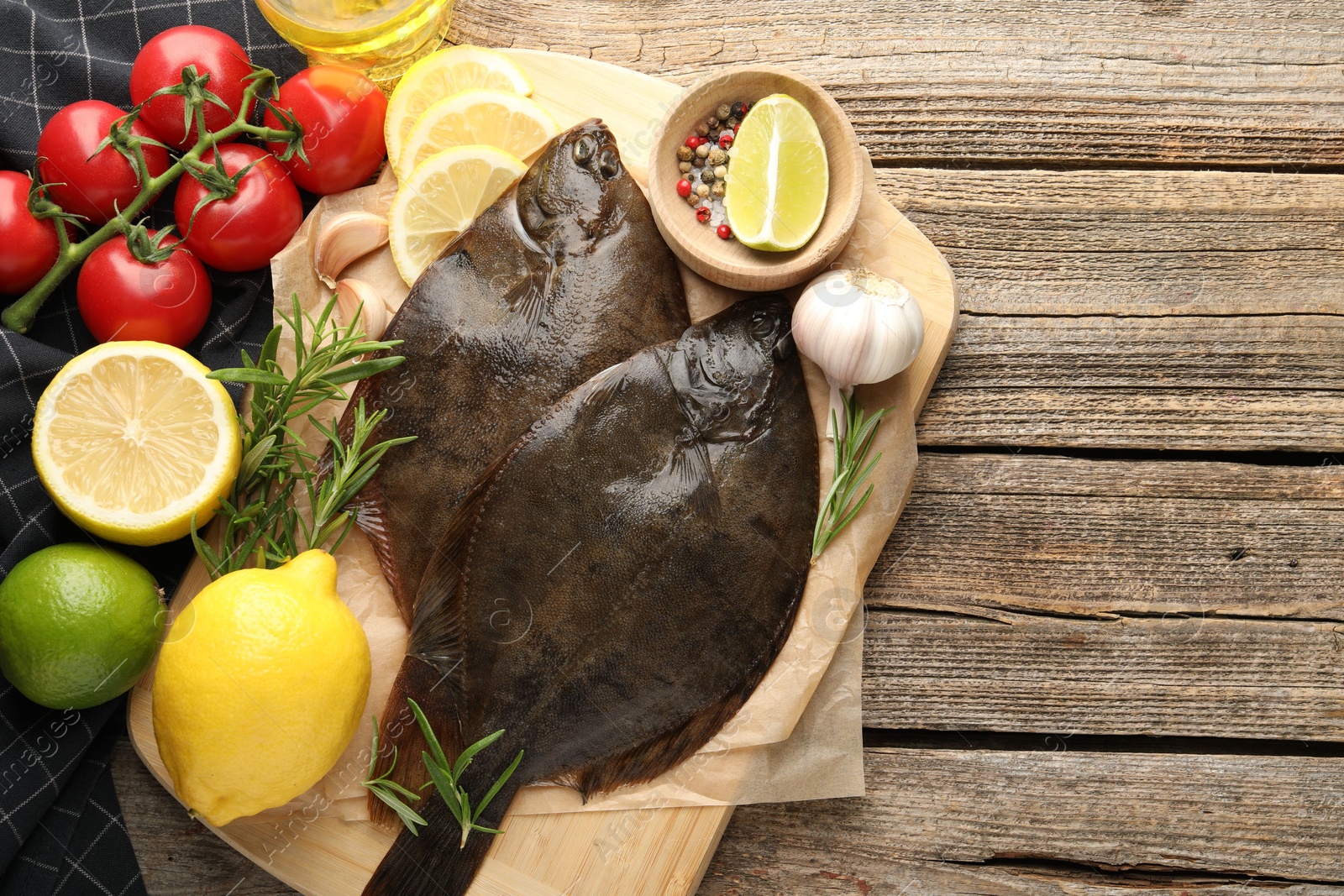 Photo of Fresh flounder fish, spices and products on wooden table, flat lay with space for text. Raw seafood