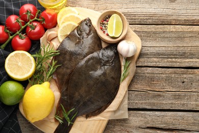 Photo of Fresh flounder fish, spices and products on wooden table, flat lay with space for text. Raw seafood