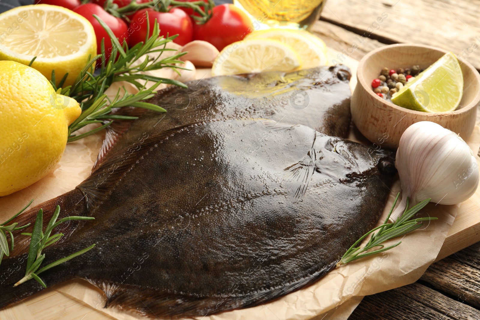 Photo of Fresh flounder fish, spices and products on wooden table, closeup. Raw seafood