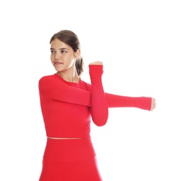 Photo of Teenage girl in sportswear stretching on white background