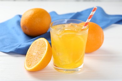 Photo of Refreshing soda water with orange slice in glass and fresh fruits on white wooden table, closeup
