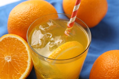 Photo of Refreshing soda water with orange slice in glass and fresh fruits on table, closeup