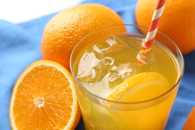 Photo of Refreshing soda water with orange slice in glass and fresh fruits on table, closeup