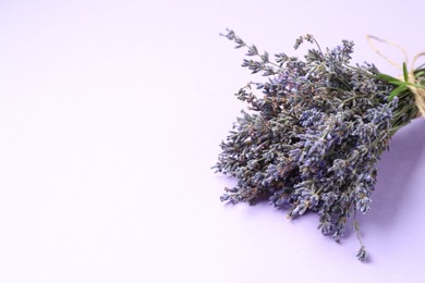 Photo of Beautiful lavender flowers on light violet background, closeup. Space for text