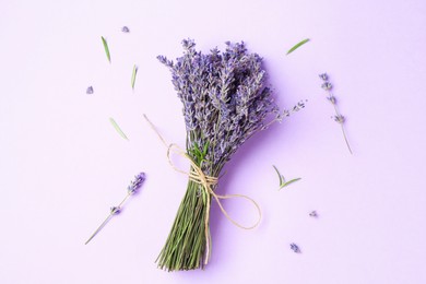 Photo of Bunch of beautiful lavender flowers, leaves and sprigs on violet background, flat lay