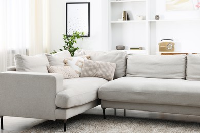 Photo of Soft sofa in light living room. Interior design