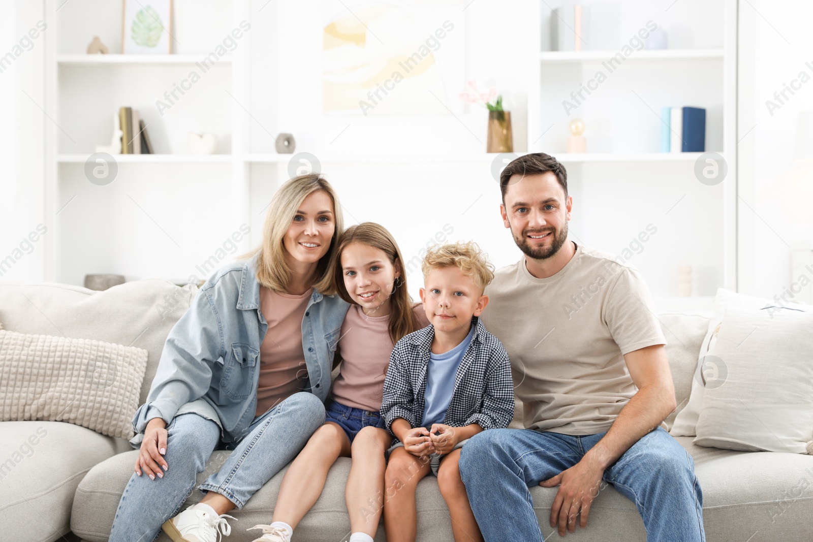 Photo of Happy family sitting on sofa at home