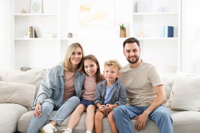 Photo of Happy family sitting on sofa at home