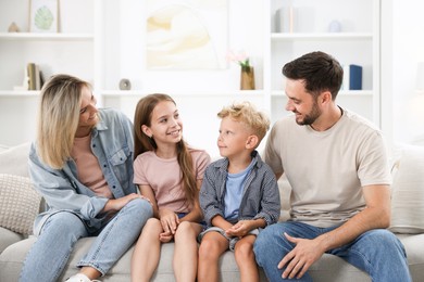 Photo of Happy family sitting on sofa at home