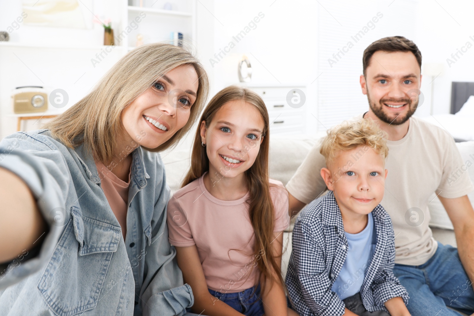 Photo of Happy family taking selfie in light room