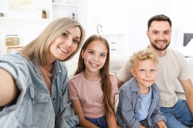 Photo of Happy family taking selfie in light room