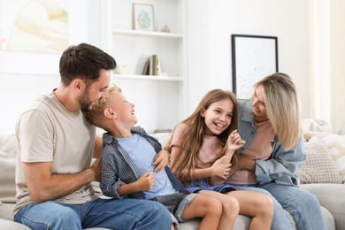 Photo of Happy family having fun on sofa at home