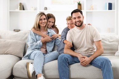 Photo of Happy family posing on sofa at home