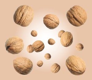 Image of Walnuts in shell swirling in air against dark beige background
