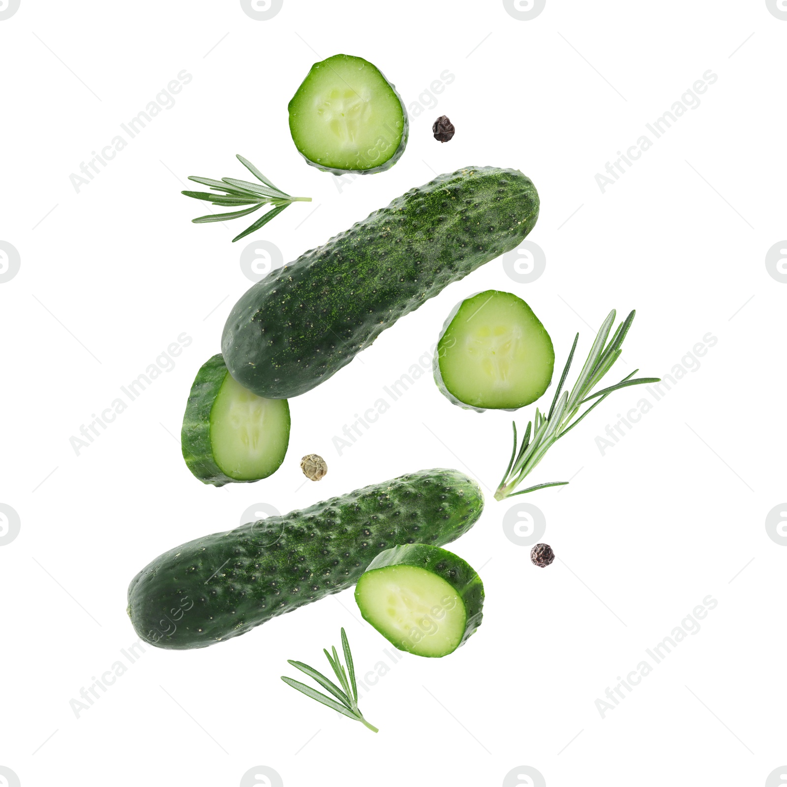 Image of Fresh cucumbers and rosemary falling against white background