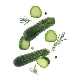Image of Fresh cucumbers and rosemary falling against white background