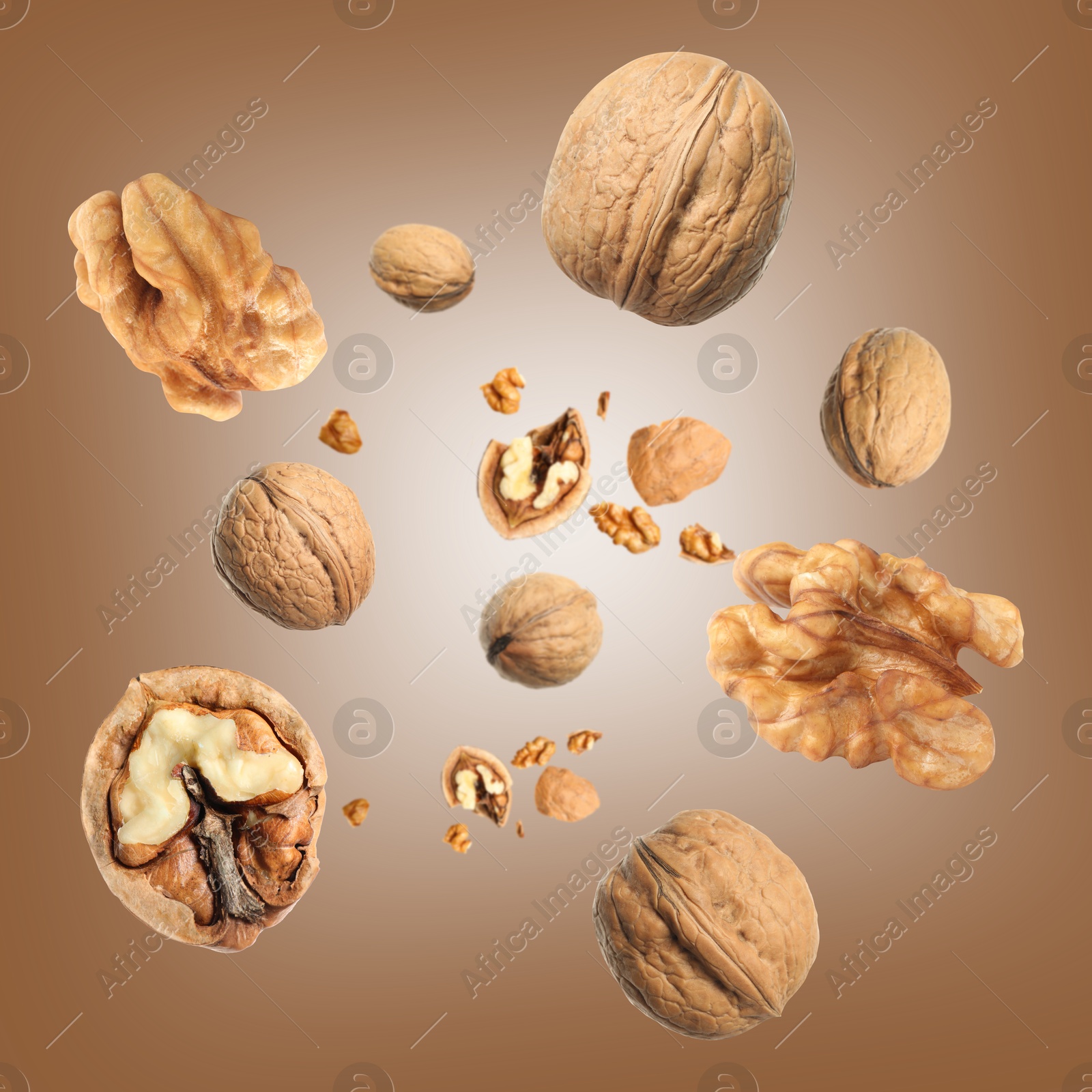 Image of Walnuts swirling in air against brown background