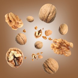 Image of Walnuts swirling in air against brown background