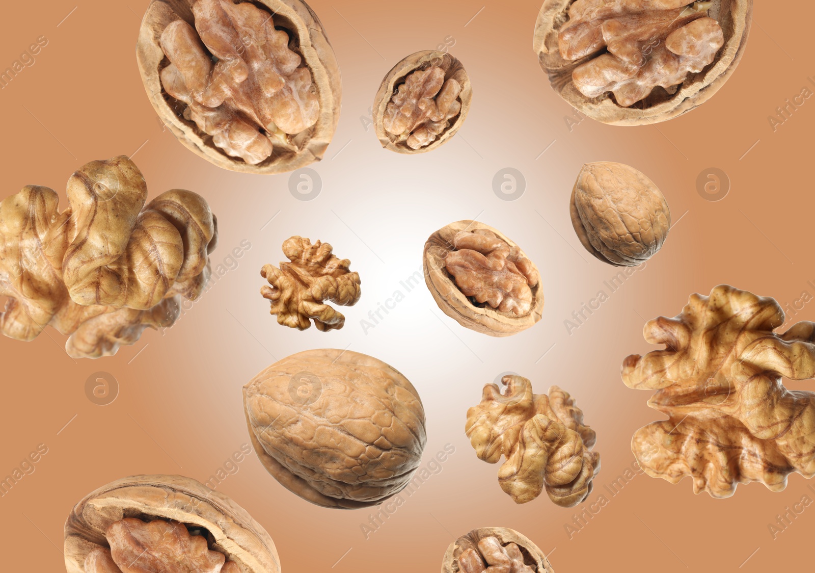 Image of Walnuts swirling in air against pale brown background