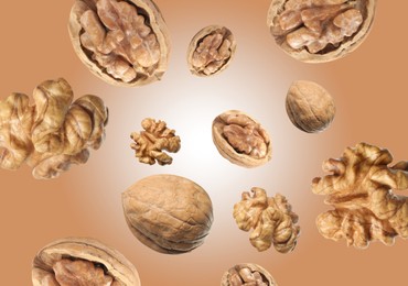 Image of Walnuts swirling in air against pale brown background