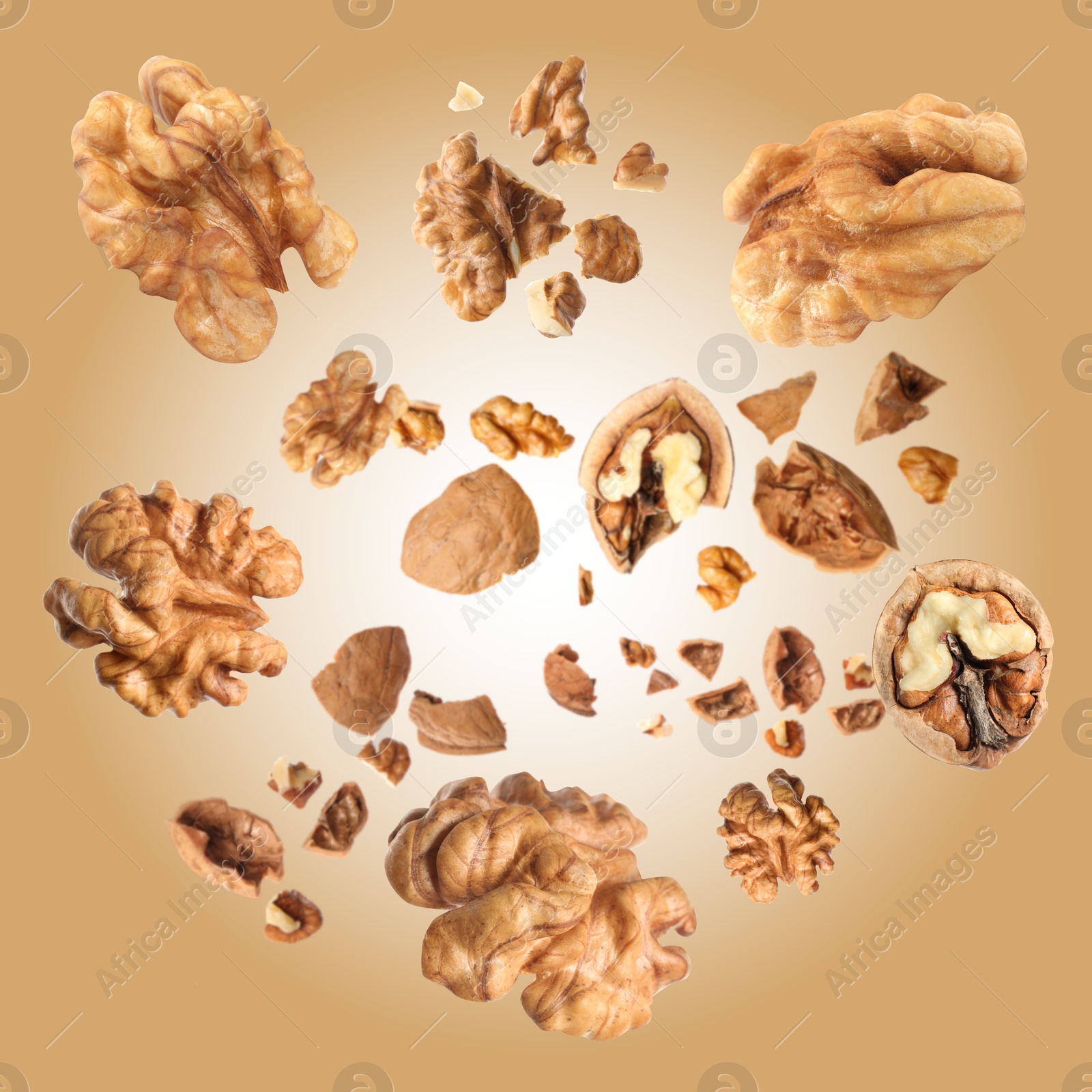 Image of Walnuts swirling in air against pale brown background