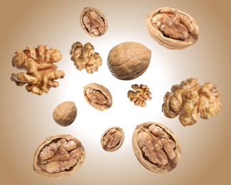 Image of Walnuts swirling in air against pale brown background