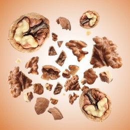 Image of Walnuts swirling in air against pale brown background