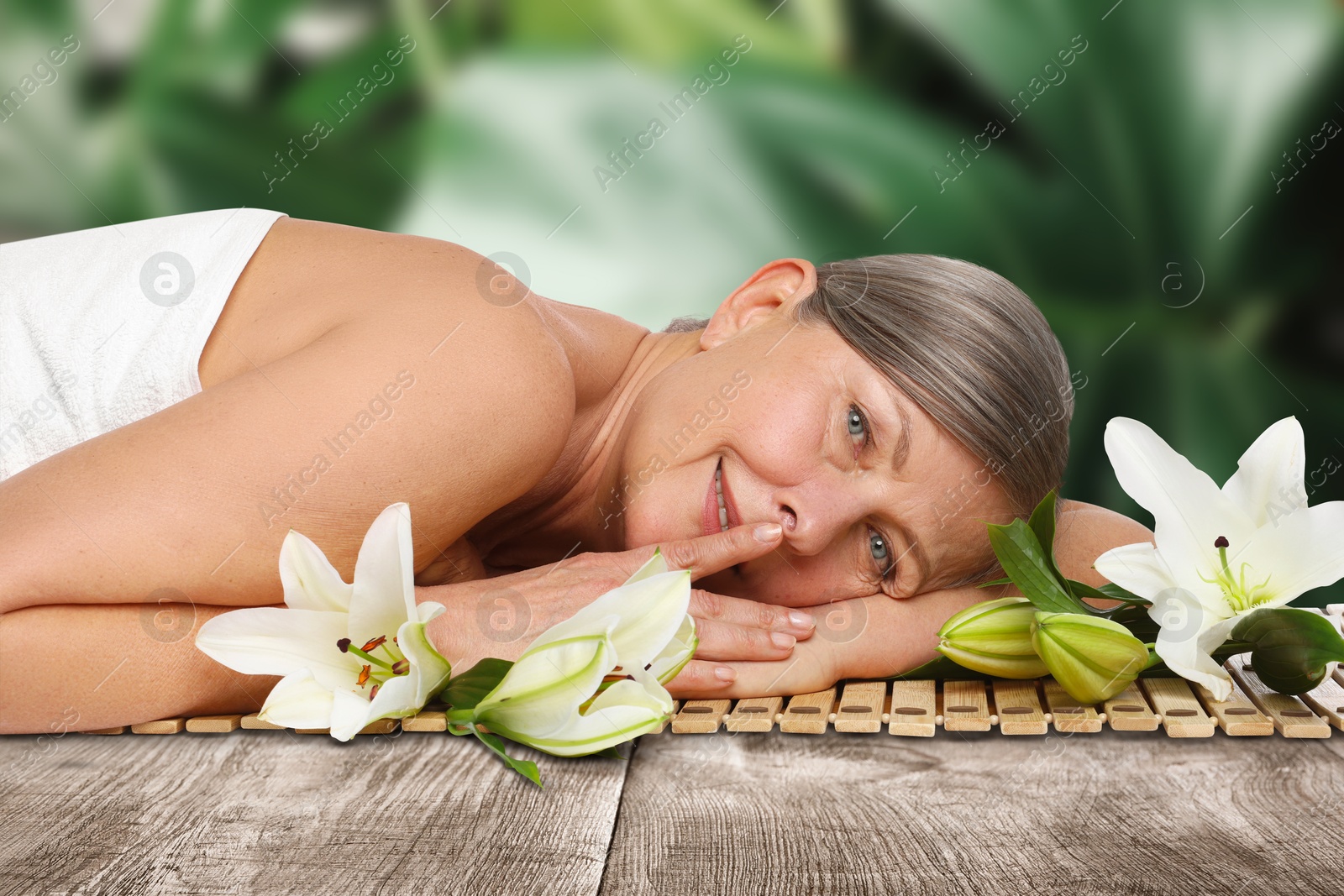 Beautiful woman relaxing on bamboo mat against blurred green background. Spa center Image of Beautiful woman relaxing on bamboo mat against blurred green background. Spa center
