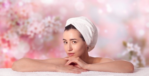 Image of Beautiful woman relaxing on towel against blurred background. Spa center