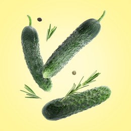 Image of Fresh cucumbers and rosemary falling against beige background