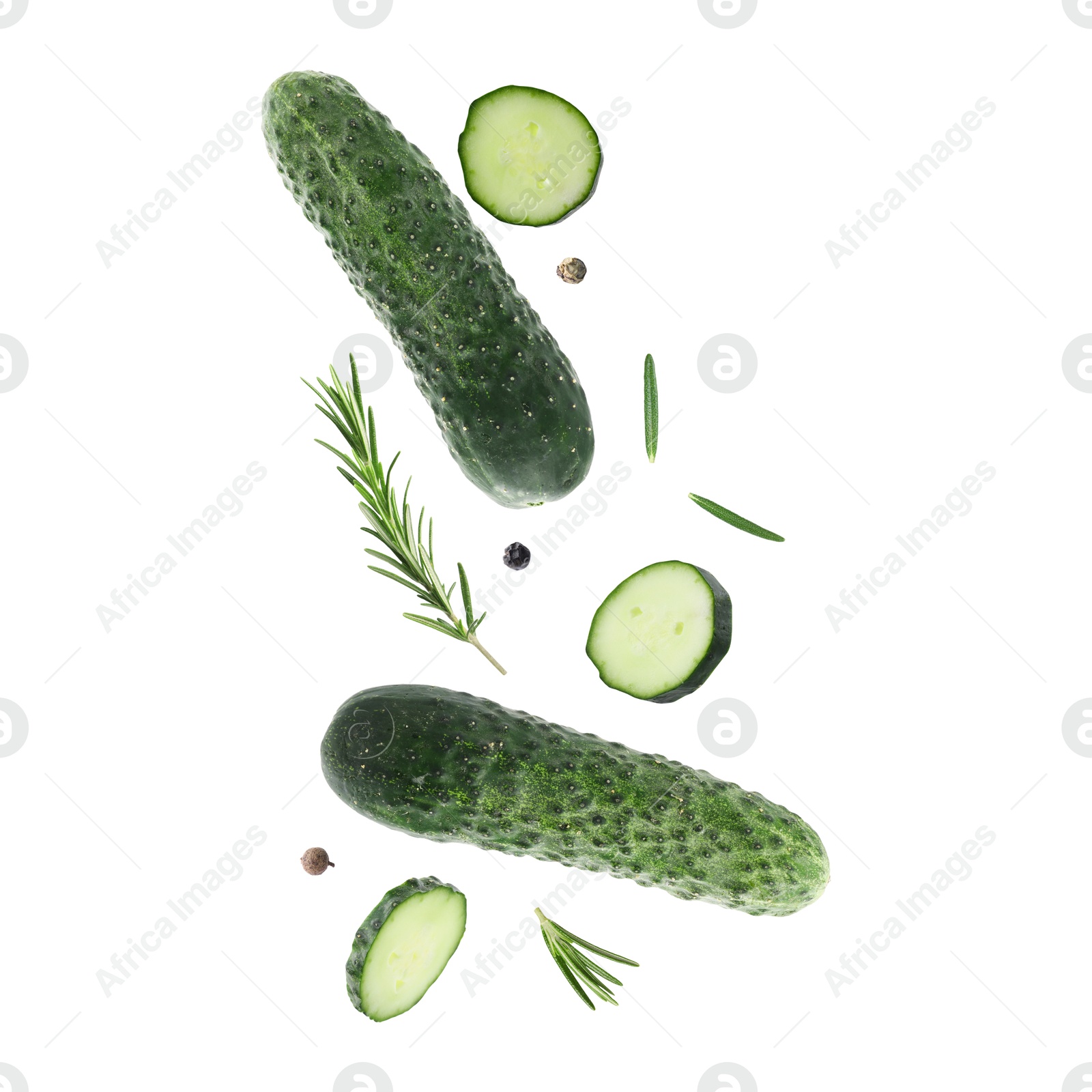 Image of Fresh cucumbers and rosemary falling against white background