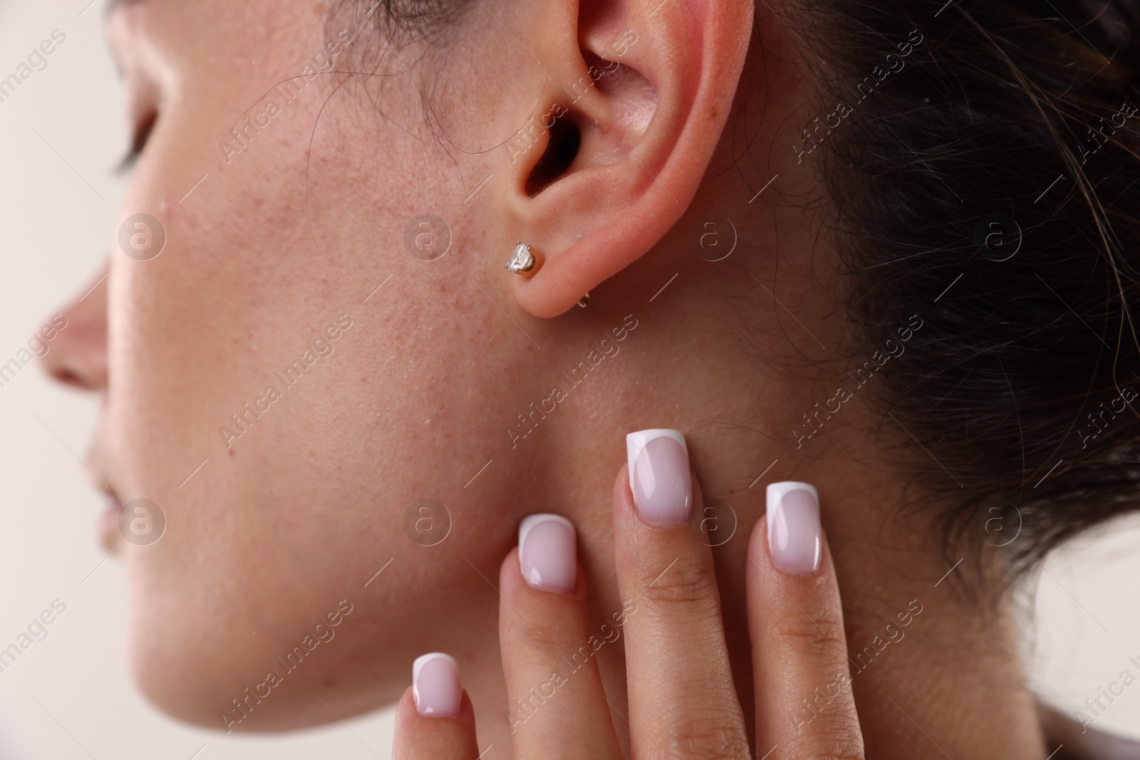 Photo of Woman wearing stylish earring on light background, closeup