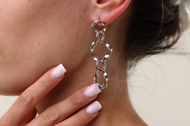 Photo of Woman wearing stylish earring on light grey background, closeup